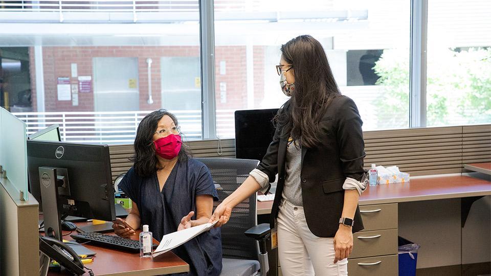 two advisors wearing masks shaking hands