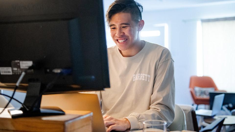 Student working behind a computer monitor