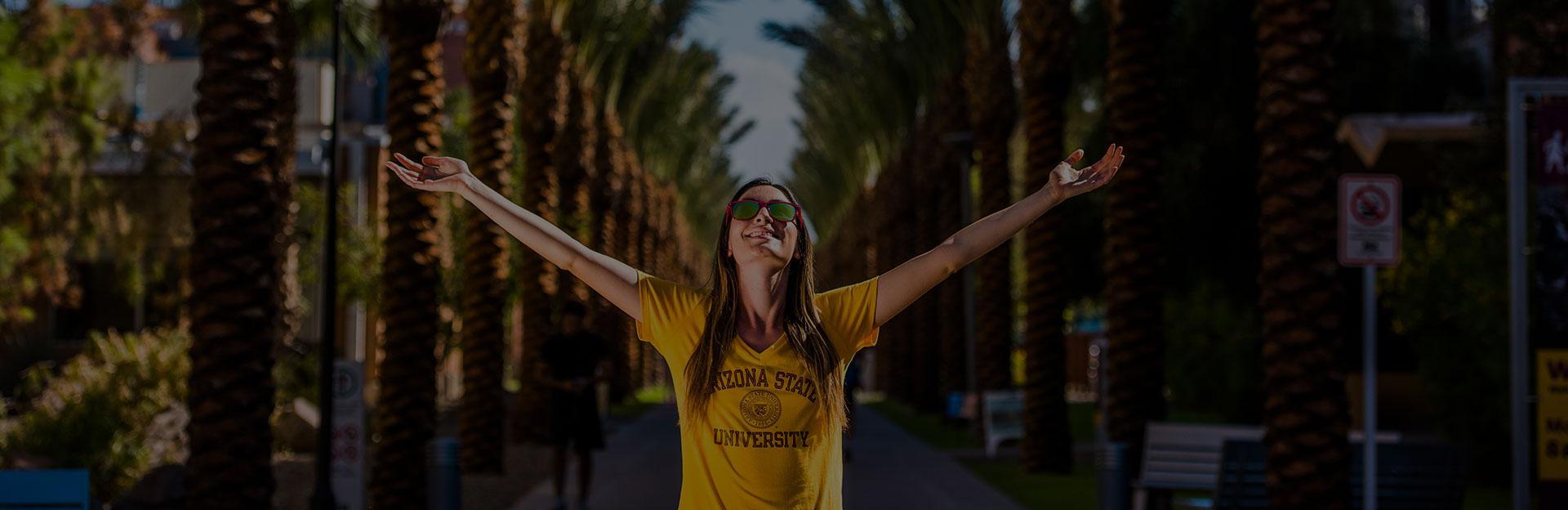 Student walking with arms held high